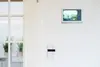 Deckenmonitor mit Kameraansicht und Bedienelementen an der Wand für smarte Heimsteuerung.